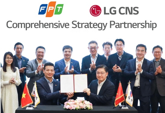 LG CNS 현신균 대표(오른쪽 다섯번째)와 FPT그룹 응우옌 반 코아(왼쪽 네번째) CEO 등 관계자가 참여한 가운데 통신·유통·서비스사업부장 박상균 전무와 FPT그룹 부 아잉 뚜 CTO가 업무협약을 체결하고 있다.