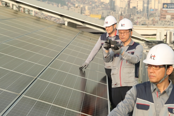 서울 관악구의 KT 구로타워 옥상에 구축된 태양광 발전소에서 KT의 에너지 전문인력들이 태양광 발전시설을 점검하고 있다.
