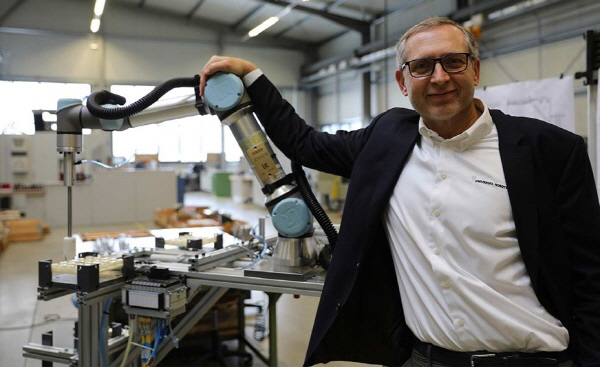 요르겐 본 홀렌 유니버설 로봇 대표가 5만번째 판매된 UR 로봇과 기념촬영을 하고 있다.