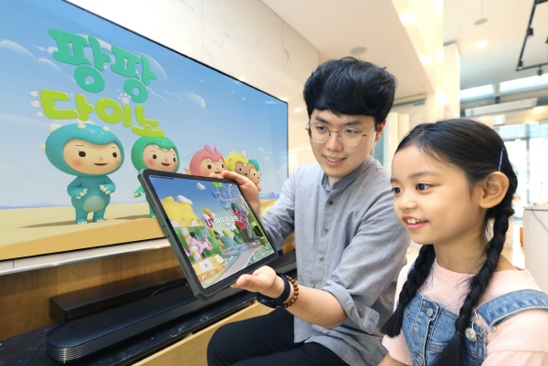 LG유플러스는 인기 애니메이션 ‘젤리고’를 제작한 드림팩토리스튜디오에 지분투자를 단행했다. 사진은 어린이 모델이 U+아이들나라와 ‘팡팡다이노’를 시청하고 있는 모습