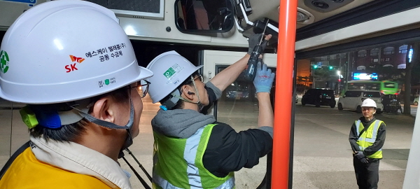 SK텔레콤 구성원들이 버스 와이파이 중계기를 구축하고 있다.